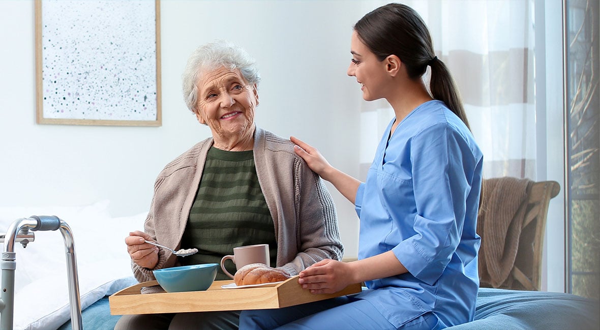 nurse helping elderly patient eat appropriate food prior to her endoscopic procedure