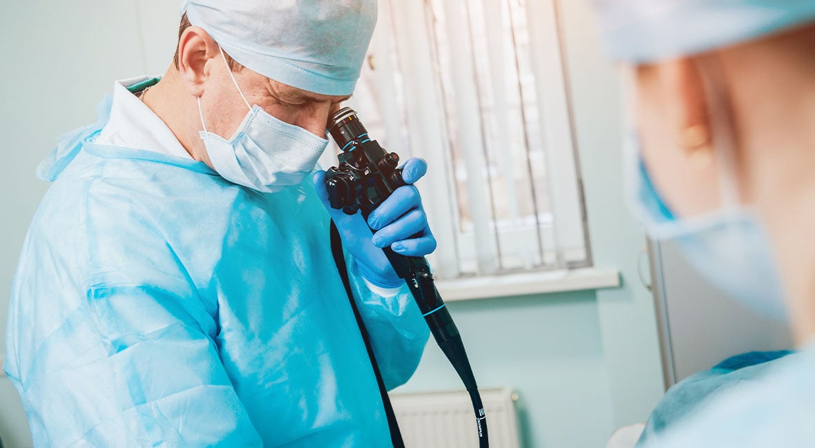  Doctor holding and looking through endoscope