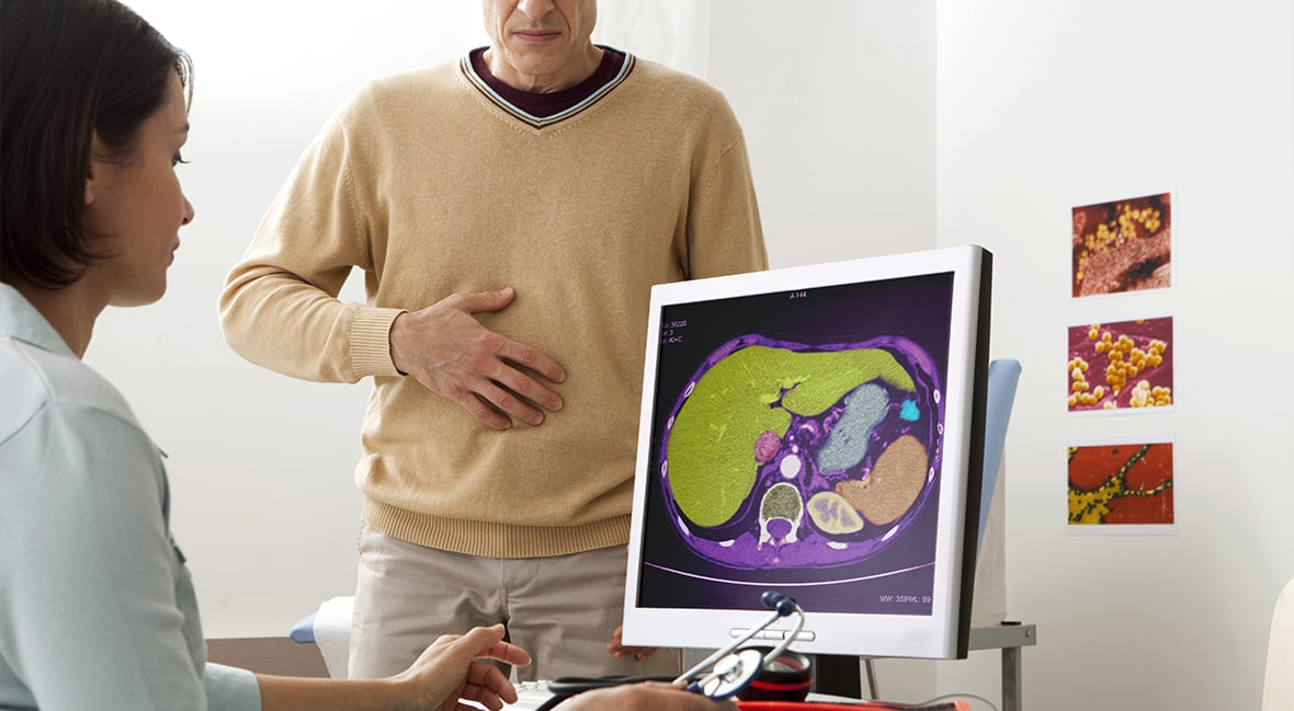 doctor reviewing results of abdominal scan with patient who is holding their stomach